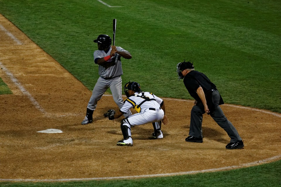 a batter, catcher, and umpire in action at home plate