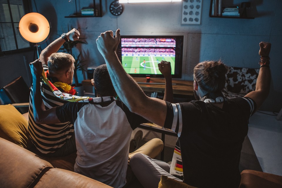 a group of soccer fans watching at home