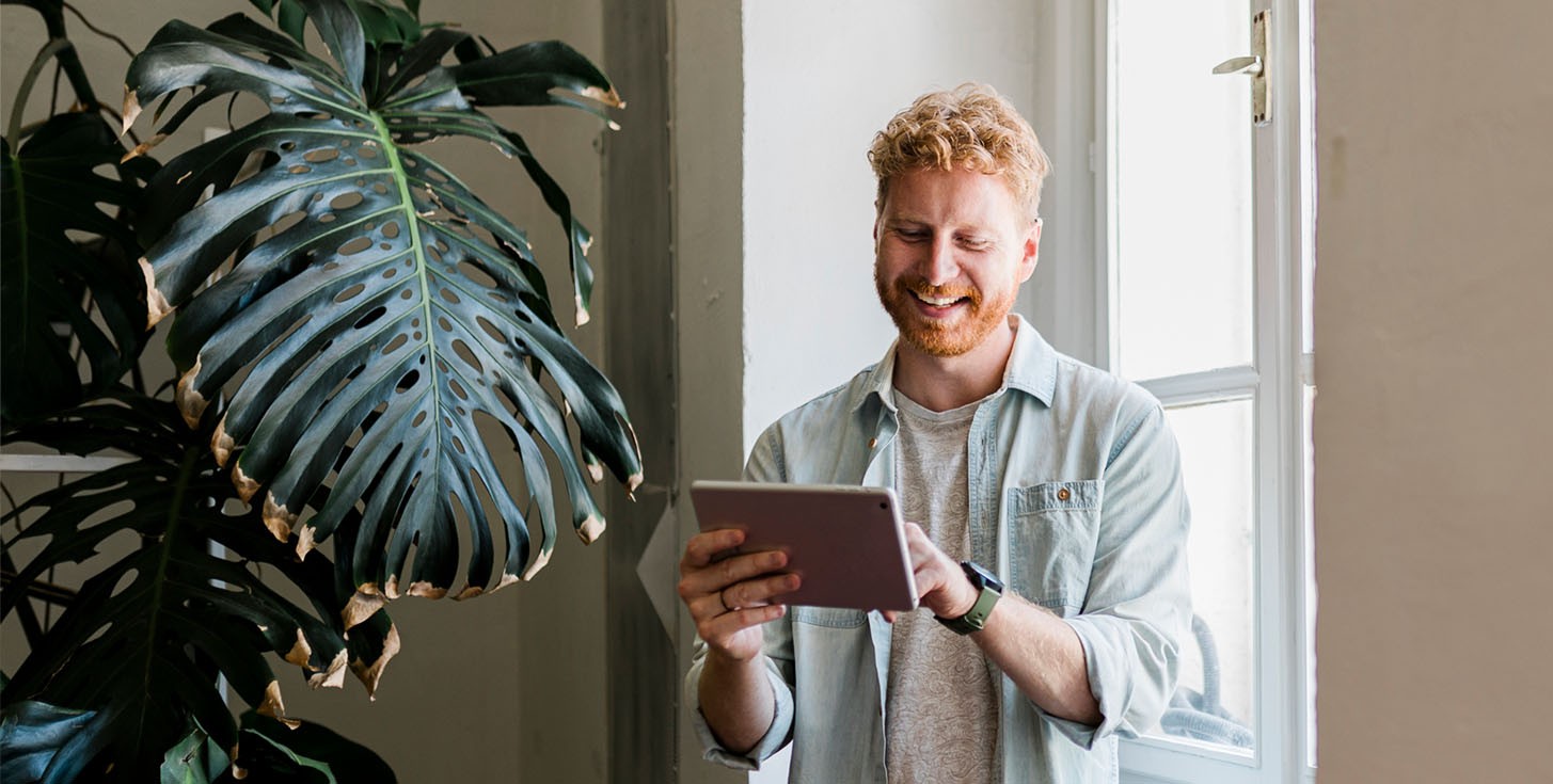 standing ginger looking happily at tablet