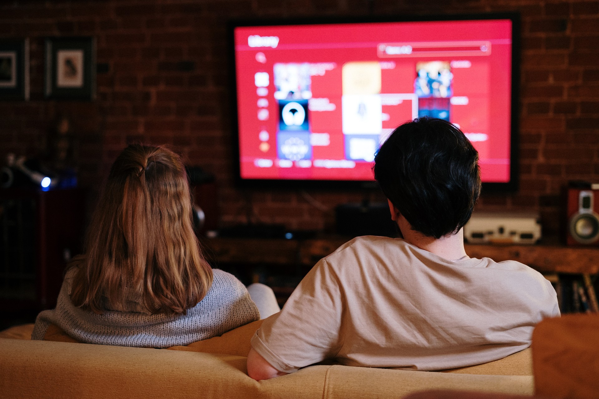 a couple sitting on a sofa watching a smart television